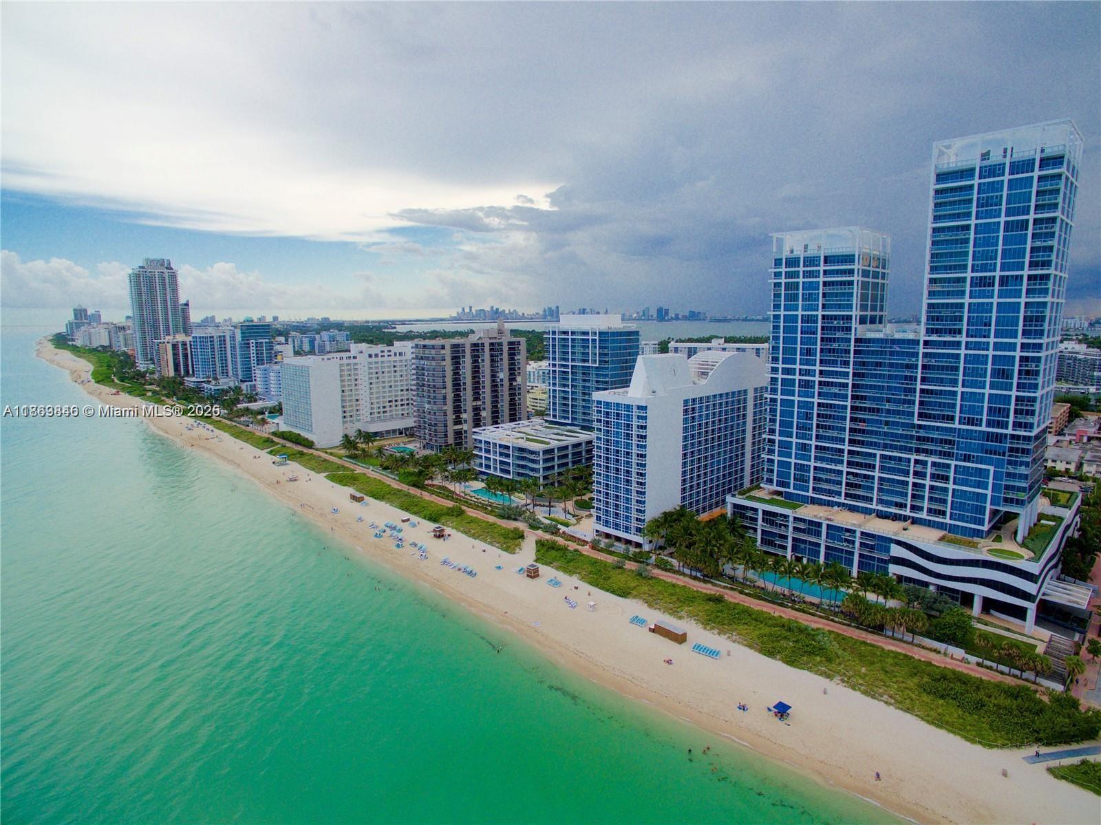An aerial view of a sandy beach lined with high-rise buildings along the ocean — 6899 Collins Ave # 808, Miami Beach FL 33141, MIAMI BEACH, FL