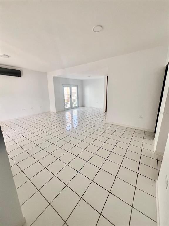 An empty room with white tiled floors, white walls, and a glass door — YAMIL GALIB PASEO LOS ROBLES UNIT 1614, MAYAGUEZ, PR
