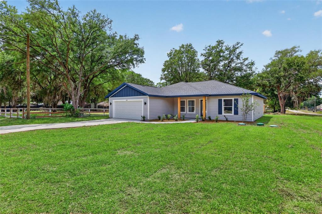A single-story house with gray siding, a blue gable, and a two-car garage — 13761 SW 114TH PLACE, DUNNELLON, FL
