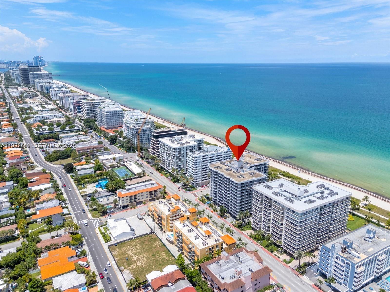 An aerial view shows a coastal city with high-rise apartment buildings along the beach — 8877 Collins Ave # 805, Surfside FL 33154, SURFSIDE, FL