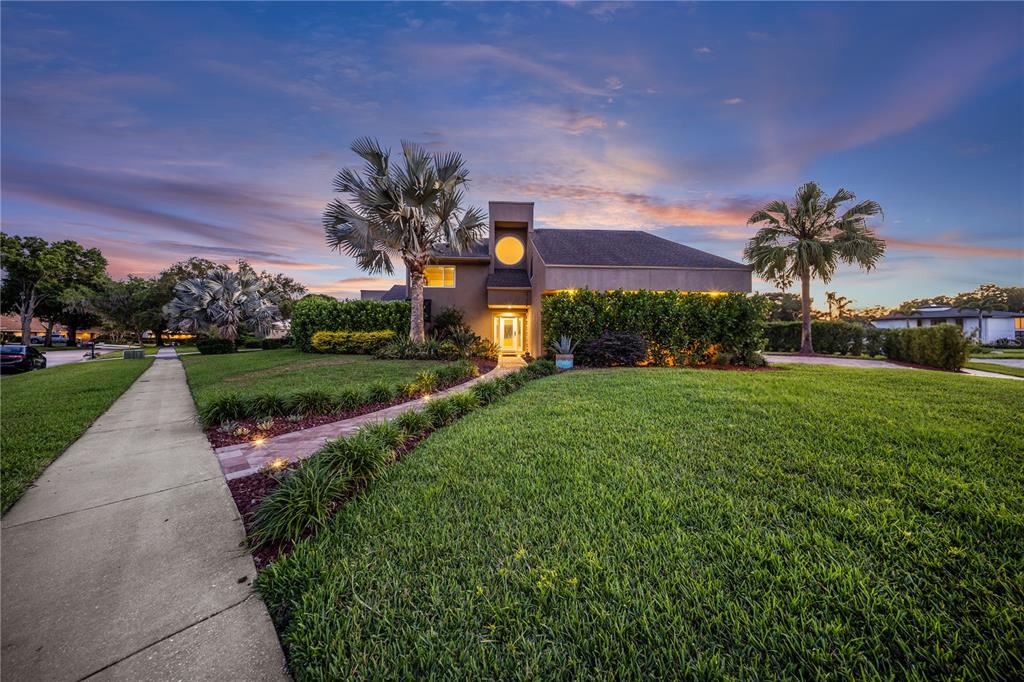 A single-family home with a circular window and palm trees at dusk — 12416 STILLWATER TERRACE DRIVE, TAMPA, FL