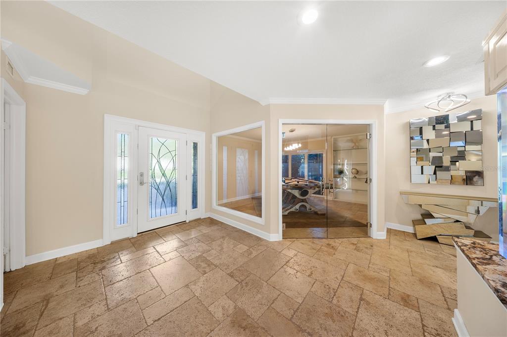 A tiled foyer features a glass-paneled front door, a large mirror, and a glass-walled room — 12416 STILLWATER TERRACE DRIVE, TAMPA, FL