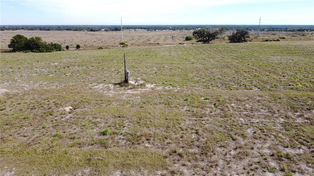 An aerial view of a large, grassy, undeveloped plot of land with a utility pole — 1/4 MOUNTAIN DRIVE, BABSON PARK, FL