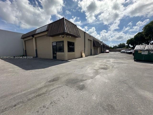 A commercial warehouse building features a tan exterior, metal roll-up doors, and a paved parking lot — 4237 NW 37 Ave # 4237, Miami FL 33142, MIAMI, FL