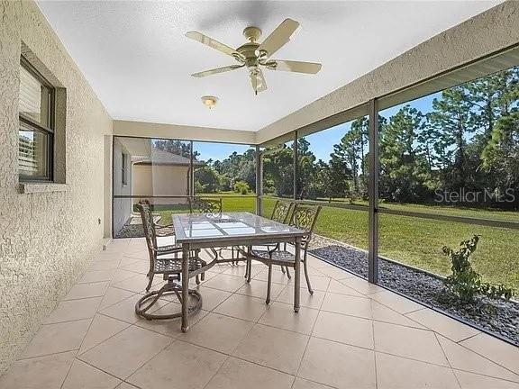 A screened-in patio features tile flooring, a dining set, and a ceiling fan — 367 MENDOZA STREET, PUNTA GORDA, FL