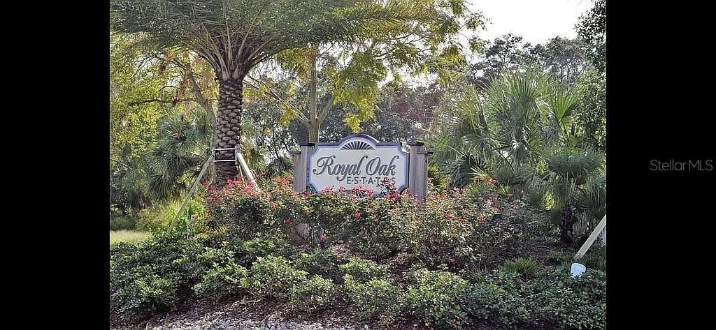 A sign for Royal Oak Estates stands in front of a palm tree and landscaping — 2949 POPLAR AVENUE, LEESBURG, FL