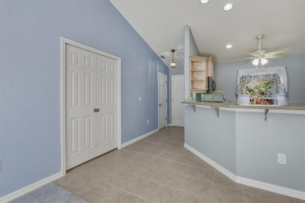 A view of a kitchen area with a breakfast bar, tiled floor, and blue walls — 3447 NADASKY AVENUE, NORTH PORT, FL