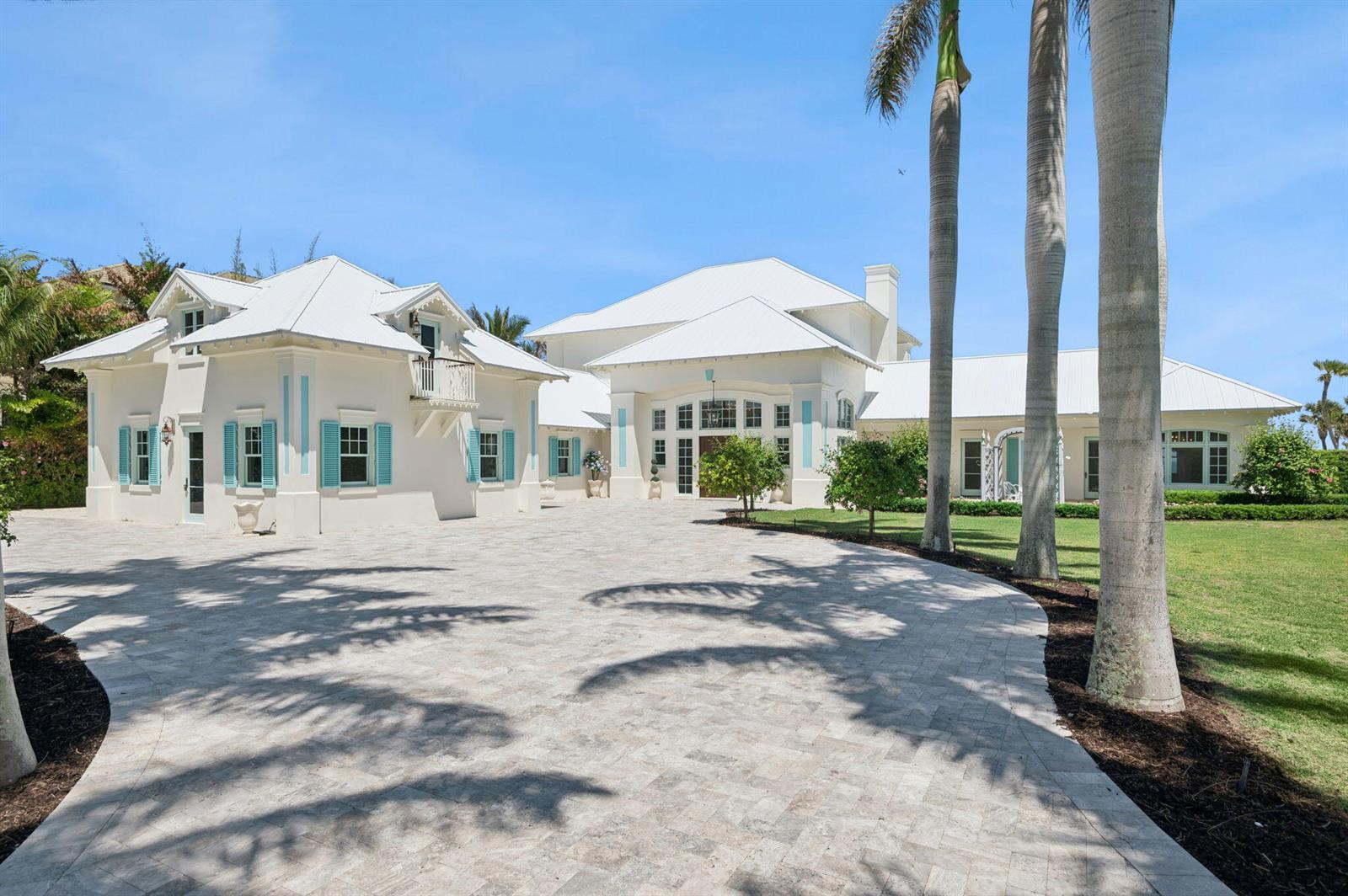 A large white house with turquoise shutters and a paved driveway under a blue sky — 716 Reef Road, Vero Beach FL 32963, VERO BEACH, FL