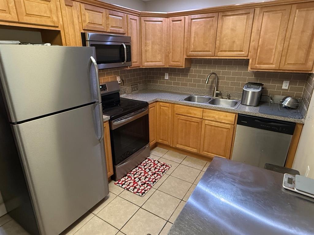 A kitchen with light wood cabinets, stainless steel appliances, and a tiled backsplash — 3142 HENDERSON CIRCLE W, LAKELAND, FL