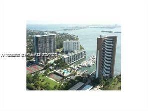 An aerial view shows high-rise residential buildings situated along a waterfront with a marina — 780 NE 69th St # 1406, Miami FL 33138, MIAMI, FL