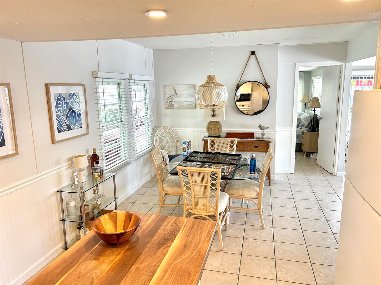 A dining area features a glass table, rattan chairs, a wooden console, and tile flooring — 312 Hibiscus Drive, Deerfield Beach FL 33442, DEERFIELD BEACH, FL