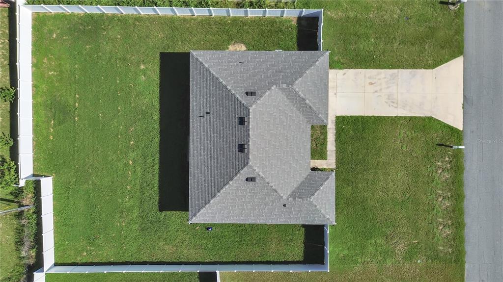 An aerial view shows a house with a gray shingled roof, driveway, and fenced yard — 15094 SW 43RD AVENUE ROAD, OCALA, FL