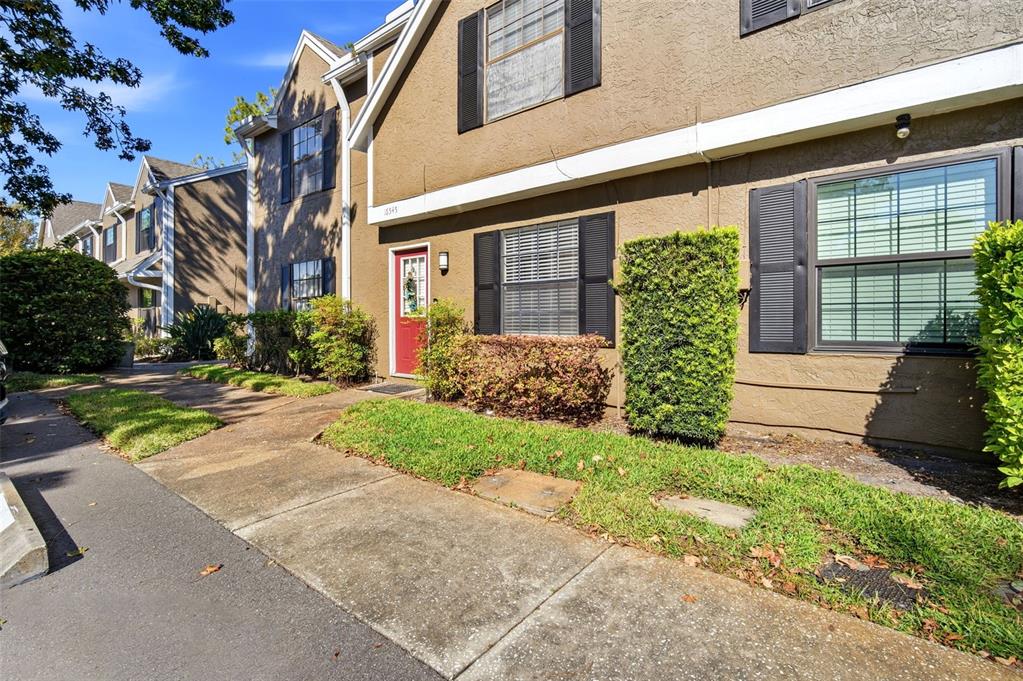 A two-story tan townhouse with a red front door and black shutters — 16545 LAKE BRIGADOON CIRCLE, TAMPA, FL