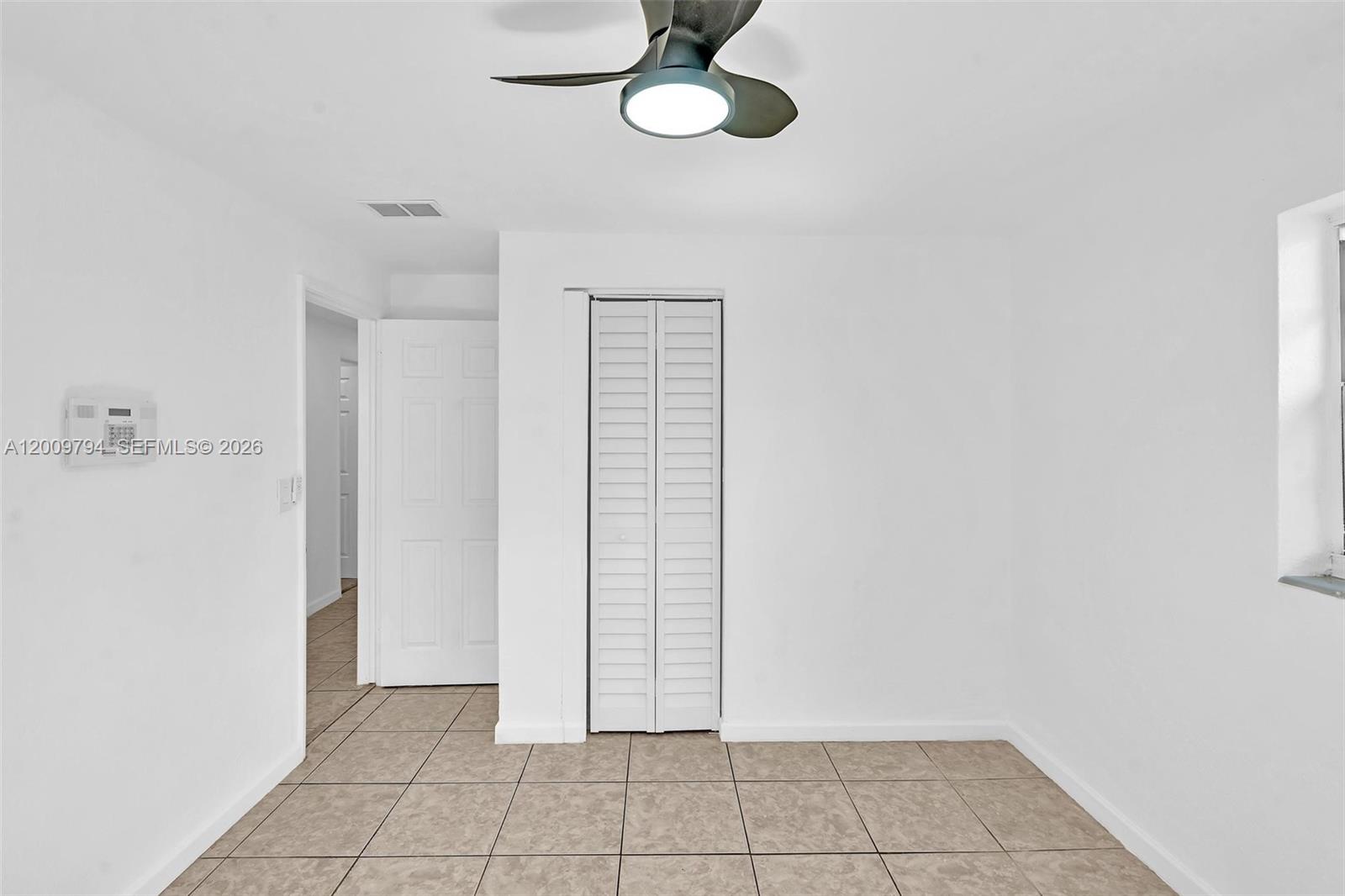 A room with white walls, tiled flooring, a ceiling fan, and a bi-fold closet door — 4156 SW 49th Ct # 0, Dania Beach FL 33314, DANIA BEACH, FL