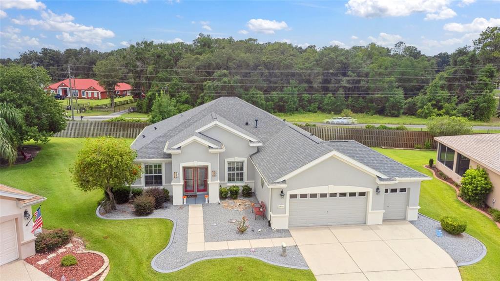 An aerial view of a single-story gray house with a garage and a landscaped yard — 13944 SE 96TH CIRCLE, SUMMERFIELD, FL