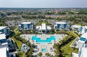 An aerial view of a residential complex featuring a central swimming pool and surrounding buildings — 1224 ROYAL VIEW TERRACE, KISSIMMEE, FL