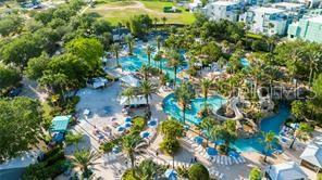 An aerial view of a resort swimming pool complex surrounded by palm trees and buildings — 1224 ROYAL VIEW TERRACE, KISSIMMEE, FL
