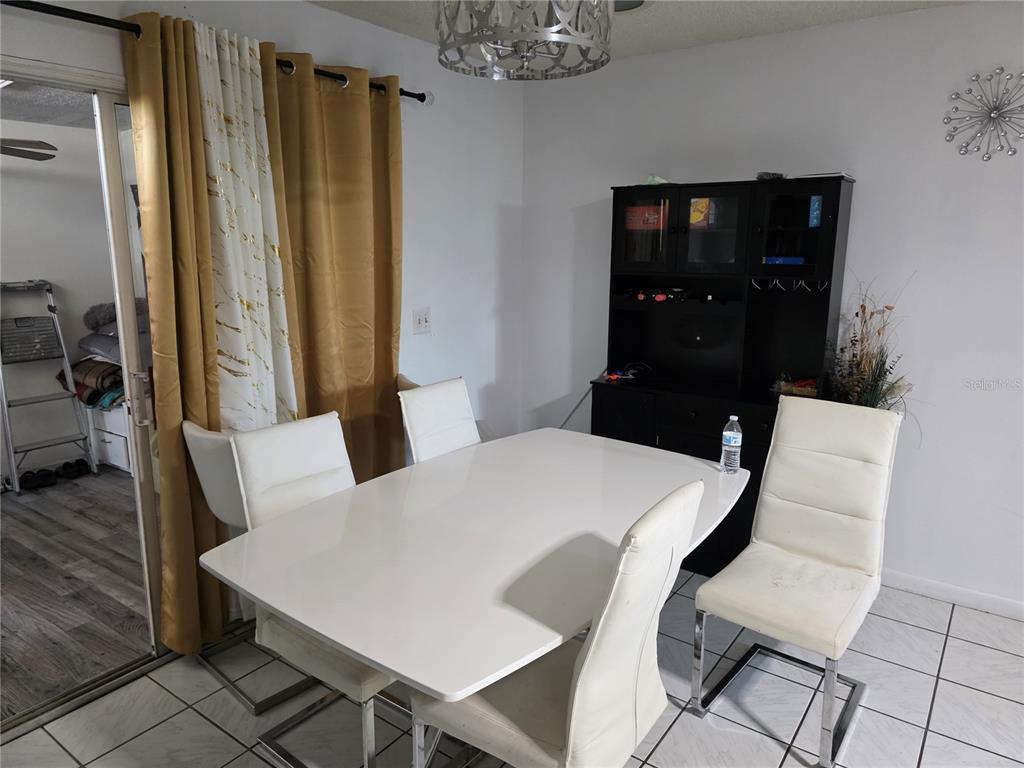 A dining room features a white table, four white chairs, and a black hutch — 142 NE 112TH AVENUE, OLD TOWN, FL