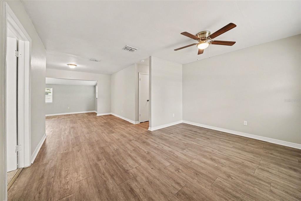 An interior view of a room with light gray walls and wood-look flooring — 1895 S IVEY LANE, ORLANDO, FL