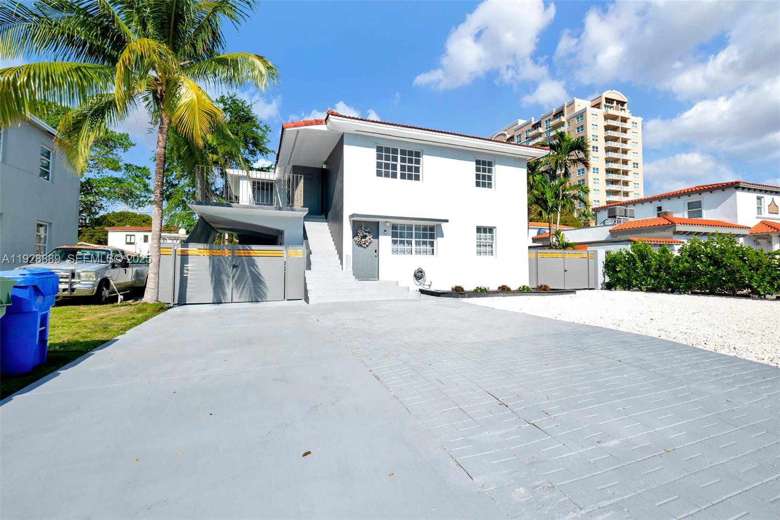 A two-story white house features a gray driveway, a palm tree, and an exterior staircase — 3711 SW 27th Ter, Miami FL 33134, MIAMI, FL