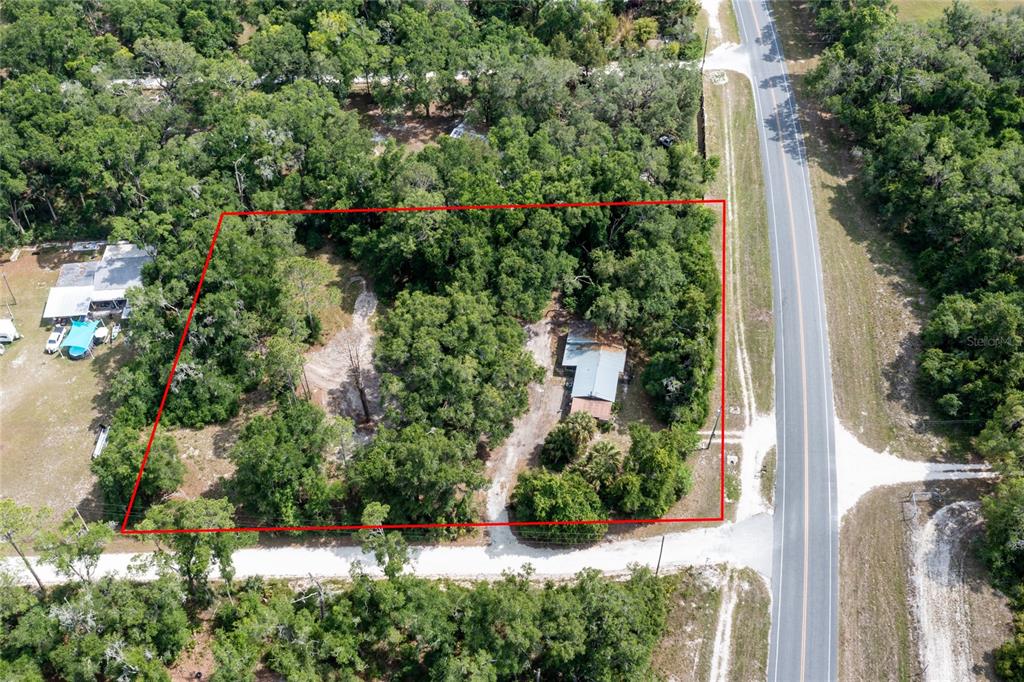 An aerial view shows a wooded lot with a house and driveway outlined in red — 9580 NE HIGHWAY 351, OLD TOWN, FL