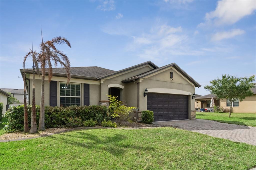A single-story house with a stucco exterior, a two-car garage, and a landscaped front yard — 2651 TAHOE TERRACE, ST CLOUD, FL