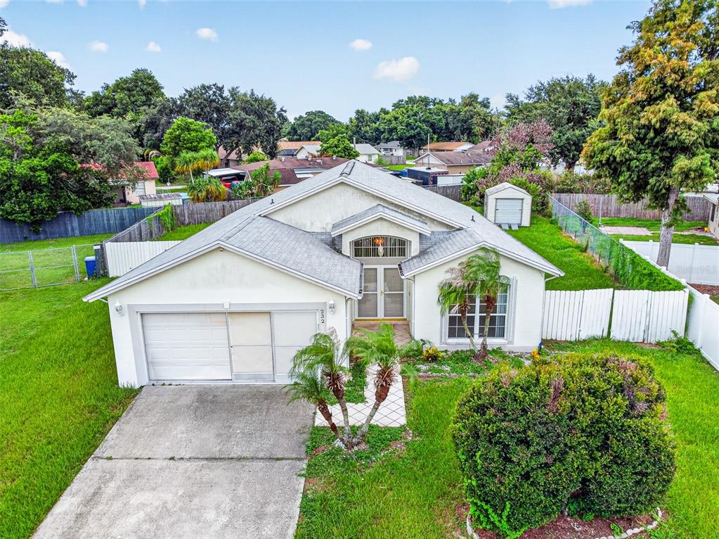 An aerial view of a single-story house with a white exterior, garage, and fenced yard — 232 KINGS POND AVENUE, WINTER HAVEN, FL