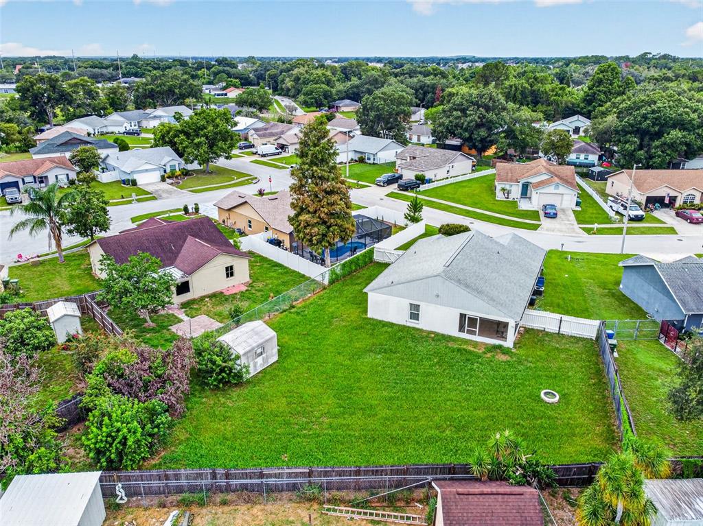 An aerial view shows a suburban neighborhood with houses, green lawns, and fenced backyards — 232 KINGS POND AVENUE, WINTER HAVEN, FL