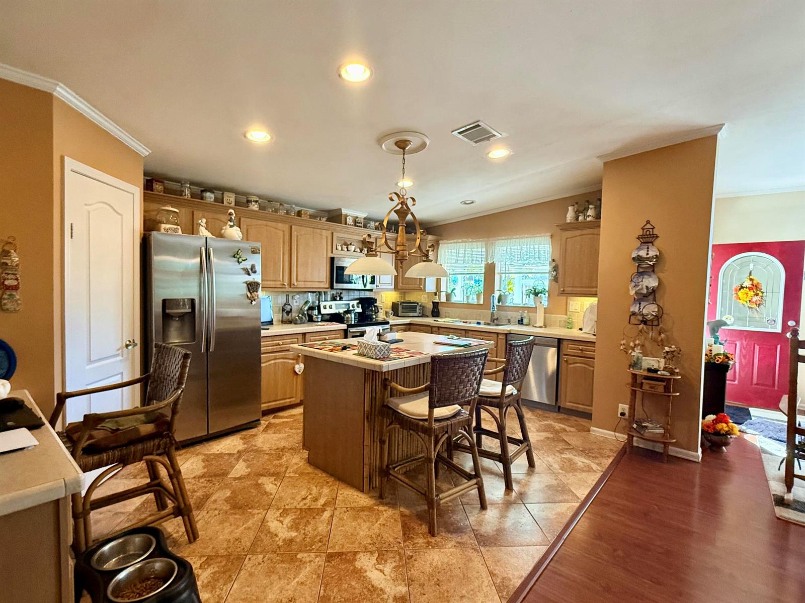 A kitchen with wood cabinets, a central island, stainless steel appliances, and tile flooring — 6403 Birch Lane, Lantana FL 33462, LANTANA, FL