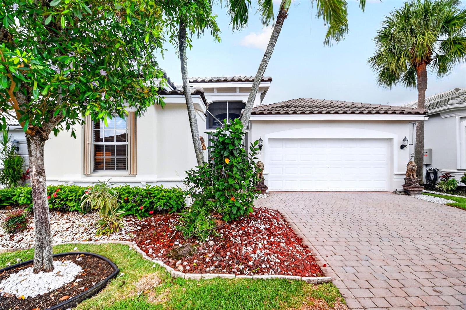 A single-story house with a white stucco exterior, a two-car garage, and a paved driveway — 9871 Agnello Street, Lake Worth FL 33467, LAKE WORTH, FL