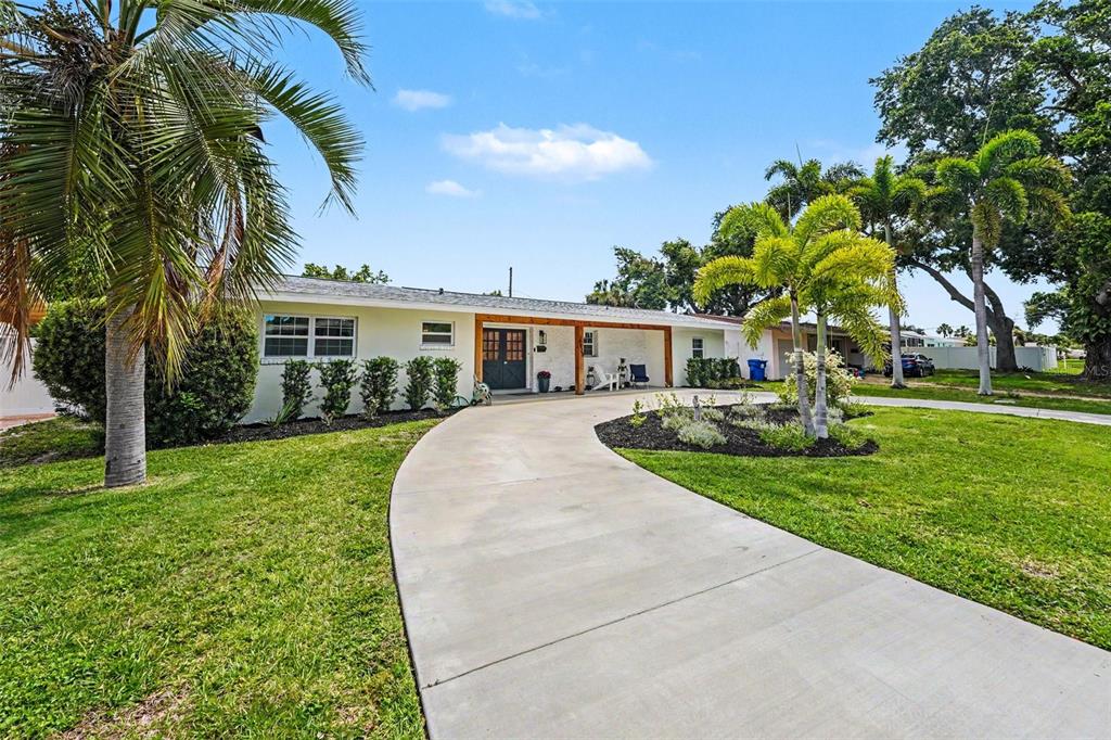 A single-story house with a curved concrete driveway, palm trees, and a covered front porch — 6825 11TH AVENUE N, ST PETERSBURG, FL