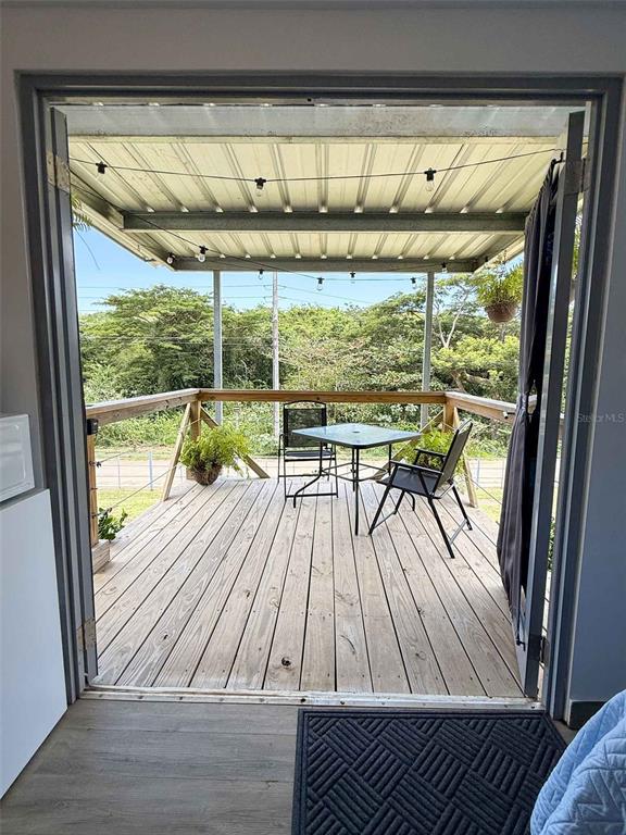 A wooden deck with a table and chairs is viewed through an open doorway — 324 CAMINO SOL, VIEQUES, PR