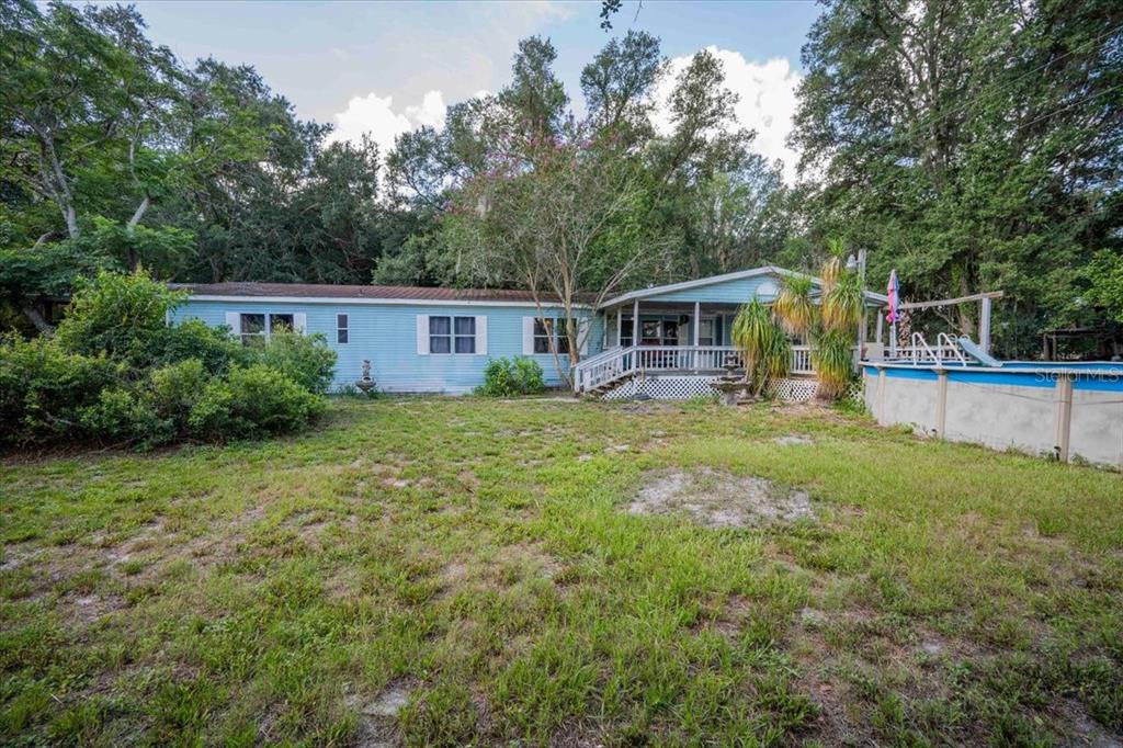 A light blue manufactured home features a front porch and an above-ground swimming pool — 2202 D R BRYANT RD, LAKELAND, FL