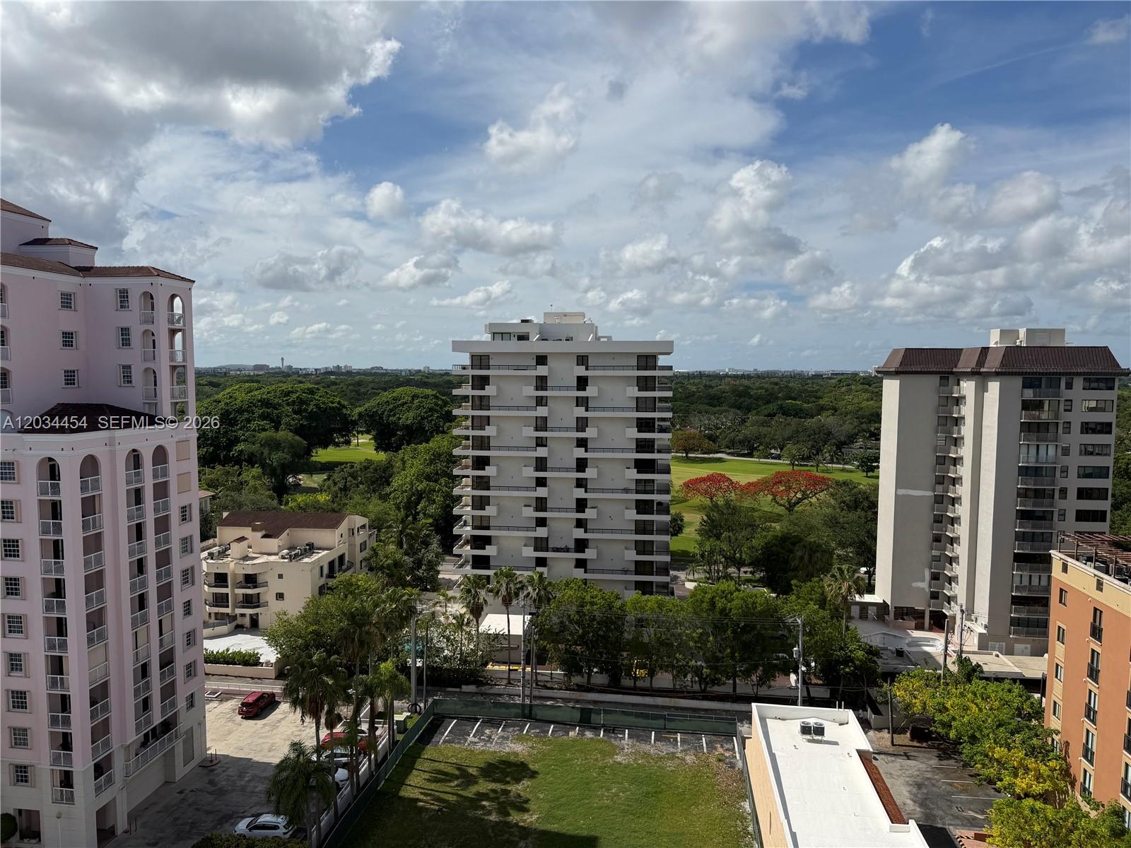 An elevated view shows several apartment buildings surrounding a golf course under a cloudy sky — 700 Biltmore Way # 1216, Coral Gables FL 33134, CORAL GABLES, FL