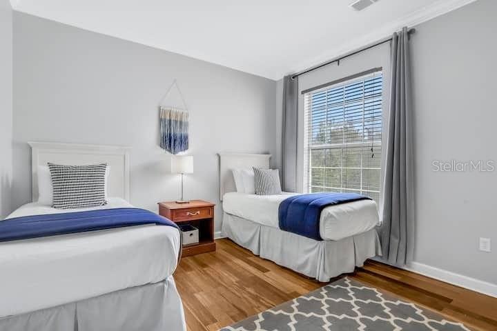 A bedroom features two twin beds, a nightstand, and a window with gray curtains — 1301 TUSCAN TERRACE UNIT 9308, DAVENPORT, FL