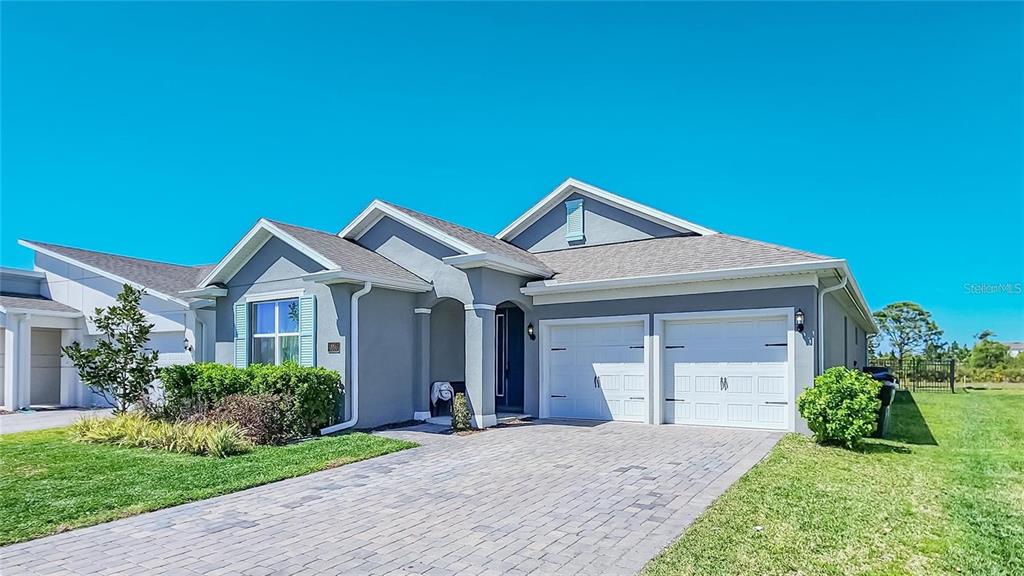 A gray, single-story suburban house features a two-car garage and a paved driveway — 18851 RAWSON STREET, ORLANDO, FL
