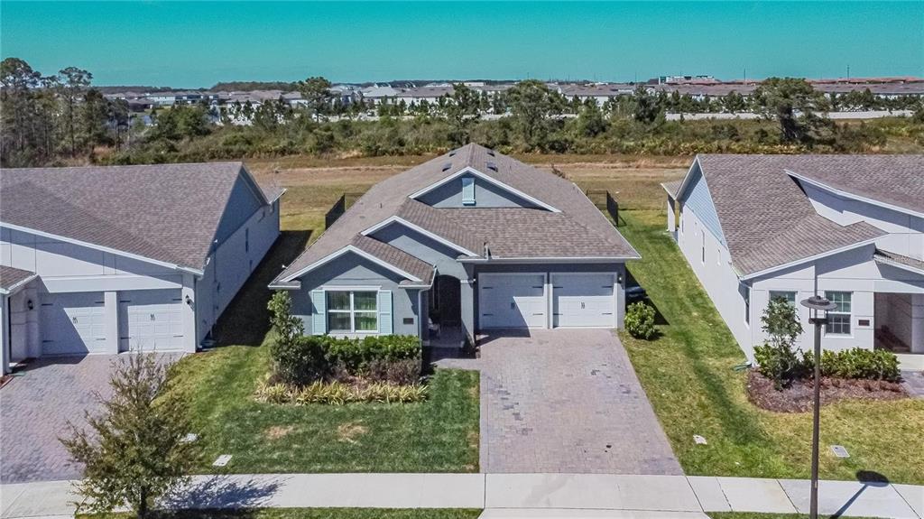 An aerial view shows a gray single-story house with a two-car garage and driveway — 18851 RAWSON STREET, ORLANDO, FL
