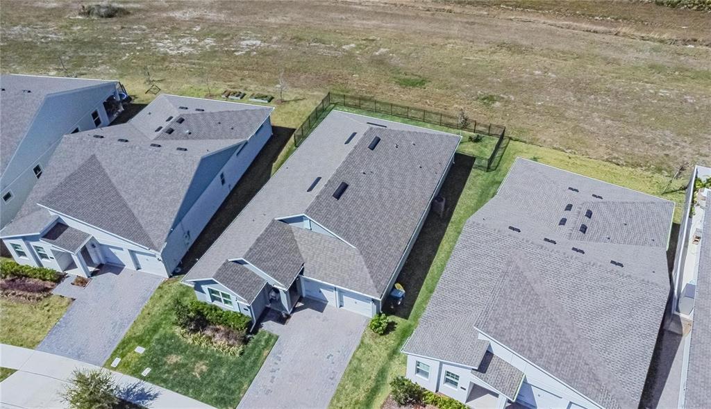 An aerial view shows three suburban houses with gray shingled roofs and paved driveways — 18851 RAWSON STREET, ORLANDO, FL