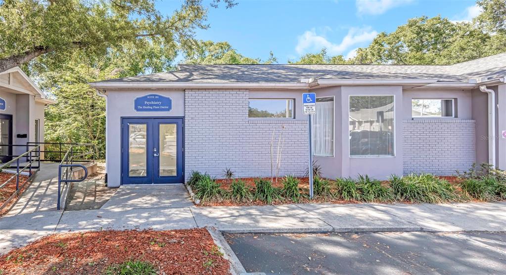 The exterior of a single-story commercial building features a blue door and brick facade — 14517 BRUCE B DOWNS BOULEVARD UNIT 301, TAMPA, FL