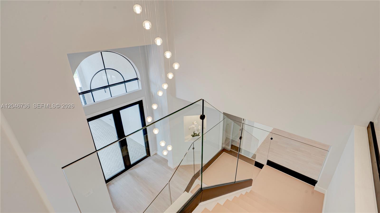 A high-angle view shows a modern staircase with glass railings and a cascading pendant light — 7956 SW 195th St, Cutler Bay FL 33157, CUTLER BAY, FL