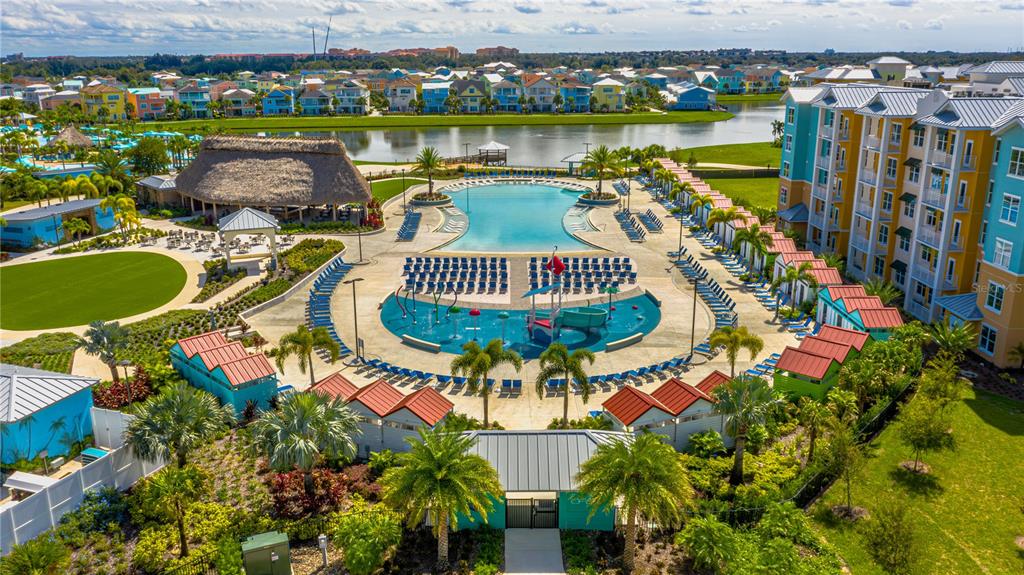 An aerial view of a resort pool area with a splash pad and surrounding buildings — 8061 VACATION AVENUE UNIT 309, KISSIMMEE, FL