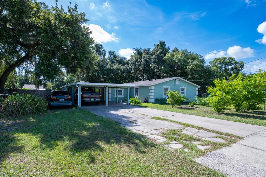 A light green single-story house with a carport and a cracked concrete driveway — 19 S TYLER AVENUE, ORLANDO, FL