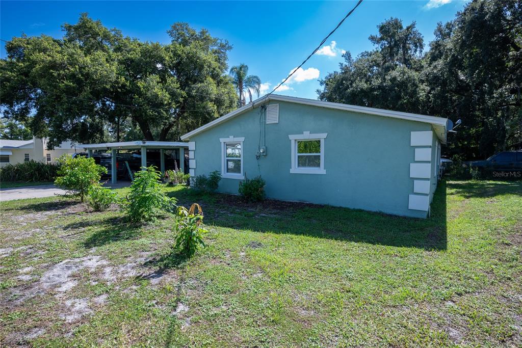 A teal-colored house exterior features a carport, two windows, and white corner trim accents — 19 S TYLER AVENUE, ORLANDO, FL