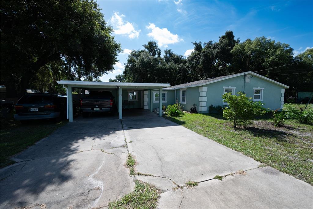 A single-story house with a light green exterior, a concrete driveway, and a covered carport — 19 S TYLER AVENUE, ORLANDO, FL