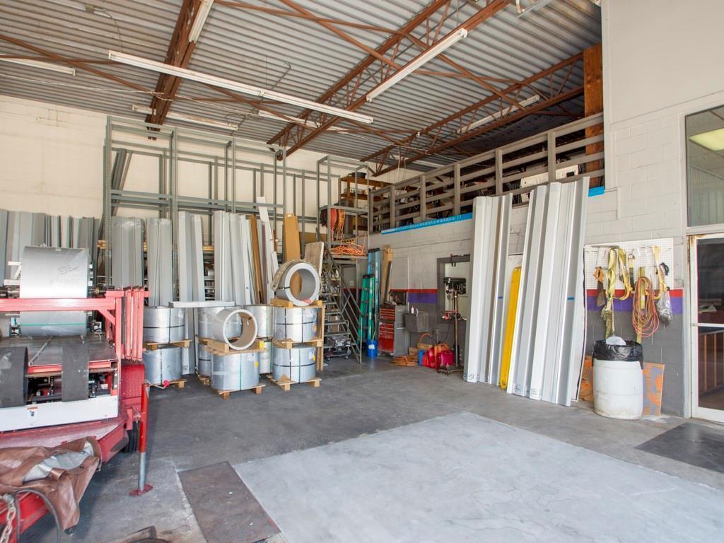 An industrial warehouse space features metal roofing panels, storage racks, and rolls of sheet metal — 415 S Us Highway 1, Vero Beach FL 32962, VERO BEACH, FL