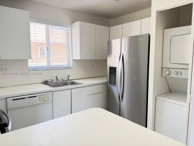 A kitchen features white cabinets, stainless steel appliances, a sink, and a stacked laundry unit — 3260 W 70th St # 202, Hialeah FL 33018, HIALEAH, FL
