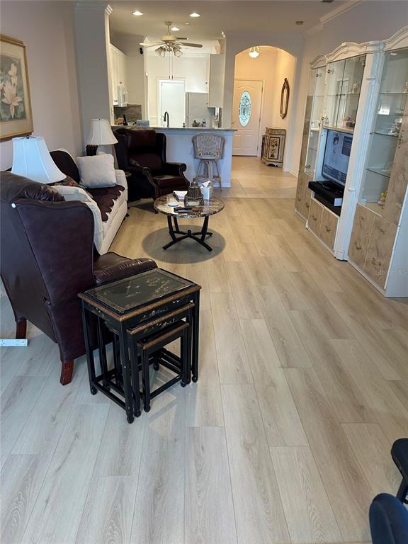 A living room features light wood-look flooring, a dark leather armchair, and a glass-topped coffee table — 1830 SAN SILVESTRO DRIVE, VENICE, FL
