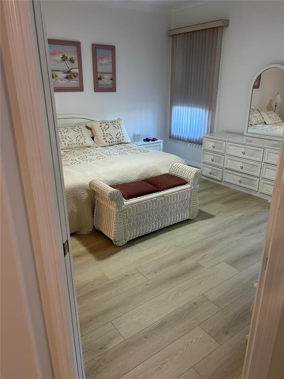 A bedroom features a white bed, a wicker storage bench, and a white dresser with mirror — 1830 SAN SILVESTRO DRIVE, VENICE, FL