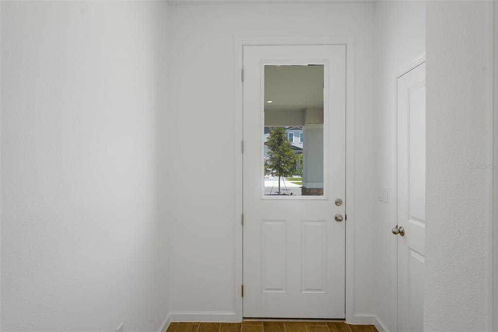 A white door with a glass panel opens into a room with white walls — 874 SUNSHOWER DRIVE, LADY LAKE, FL