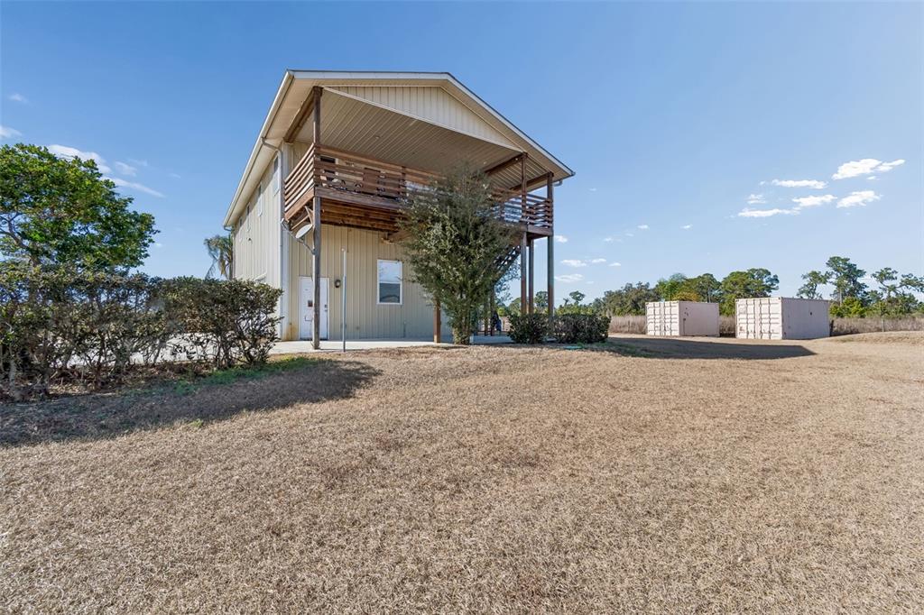 A two-story house with a wooden balcony and a large yard under a clear sky — 4026 MCINTOSH ESTATES LANE, PLANT CITY, FL